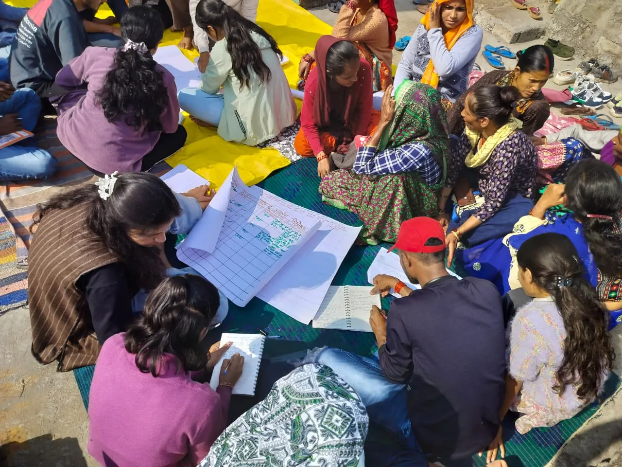 Field staff fill in survey forms with village women