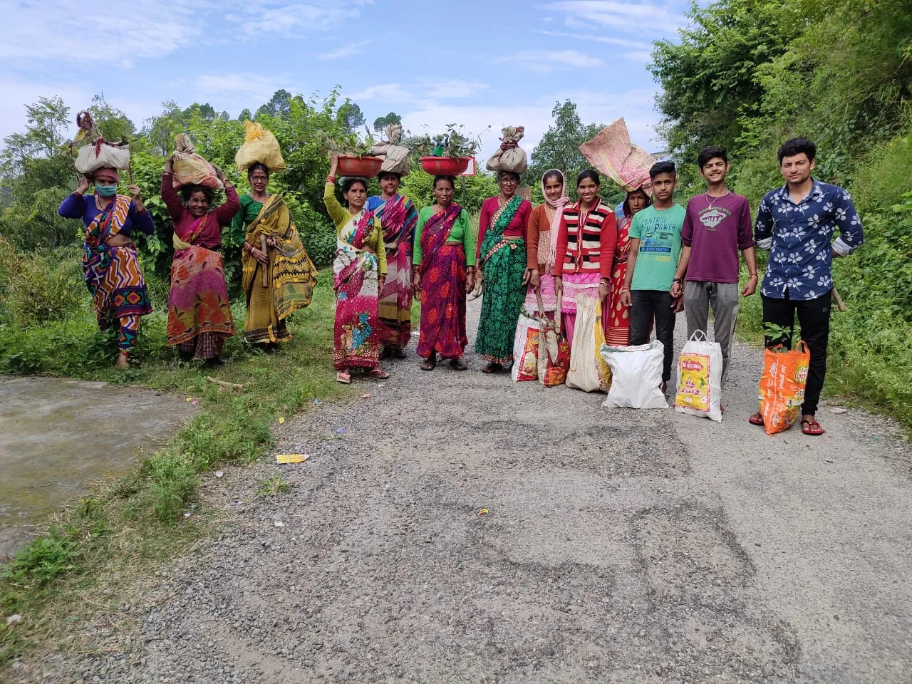 Village women on a hill road with saplings ready for planting