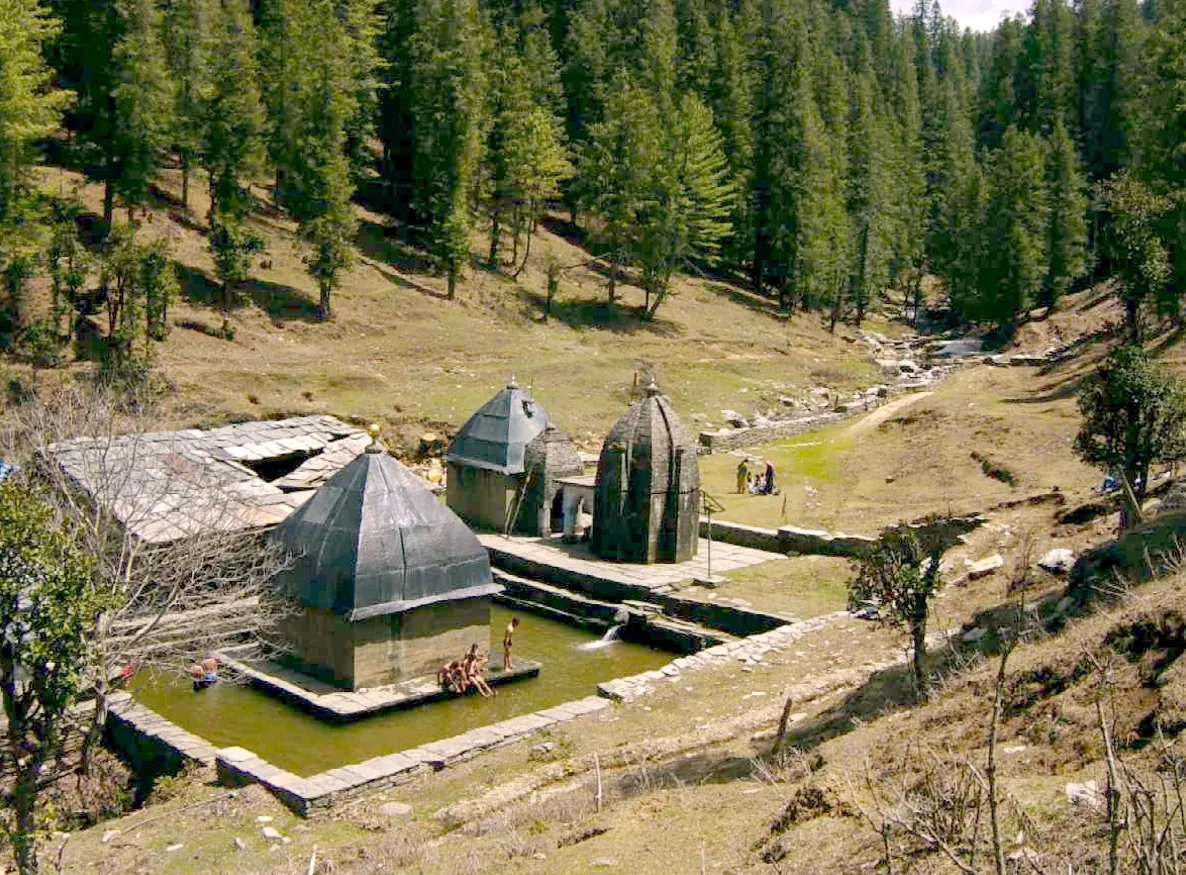 Old stone spring shrines, called naulas, in a pine forest