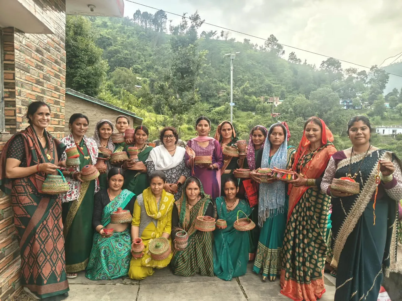 A group of village women hold up the produce they grew